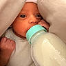 Goddess is registered to the contest to win money with this photo: baby, infant, bottle, milk, feeding, blanket, white_clothing, newborn, cute, face, hand, indoors, sleepwear, soft_texture, closeup, portrait, human, resting, cozy, caring