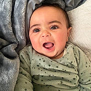 Naël a rejoint le concours — aidez-le/la à gagner de superbes lots ! baby, infant, smiling, face, eyes, mouth, pajamas, blanket, soft, cozy, child, skin, expression, indoors, cute, young, happy, lying_down, person, portrait