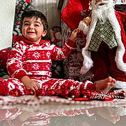 Fabio joined the competition — help win amazing prizes! toddler, child, pajamas, red, white, christmas, holiday, decorations, santa_claus, doll, floor, reflection, smile, happy, indoors, festive, ornaments, toy, cozy, celebration