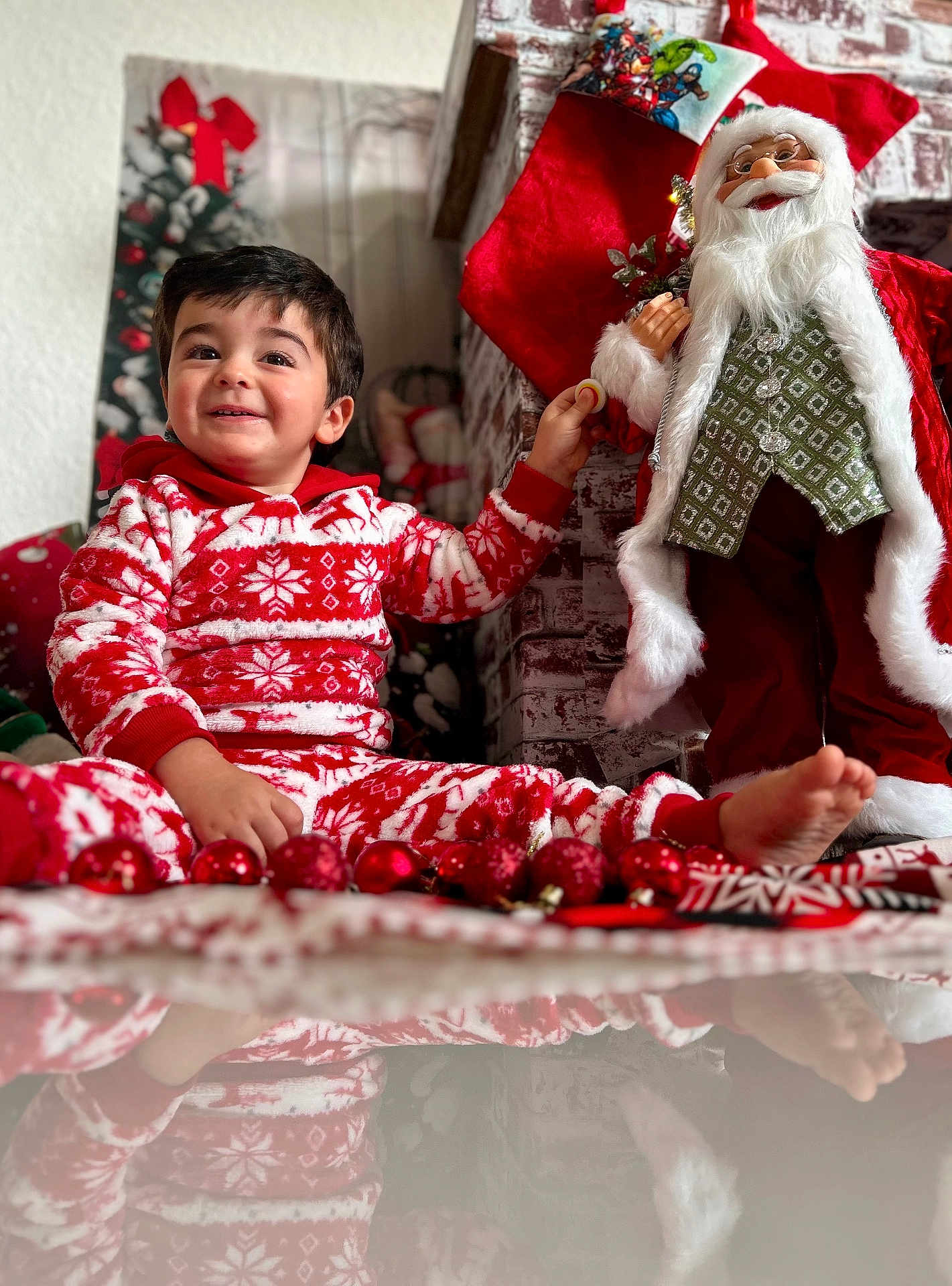 Fabio joined the competition — help win amazing prizes! toddler, child, pajamas, red, white, christmas, holiday, decorations, santa_claus, doll, floor, reflection, smile, happy, indoors, festive, ornaments, toy, cozy, celebration