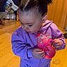 Janiyah joined the competition — help win amazing prizes! toddler, child, purple_tracksuit, nike, sippy_cup, pink, hair_clips, curly_hair, indoors, wooden_floor, child_holding_object, casual_clothing, young_child, cute, person, small_child, floor, hair_style, standing, playful