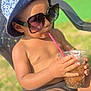 child, toddler, sunglasses, bucket_hat, hat, drink, plastic_cup, straw, chair, outdoor, sunny, summer, bare_torso, swimwear, legs, grass, backyard, vacation, relaxing, portrait