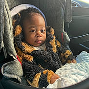 Këllyan participe au concours pour gagner de l'argent avec cette photo : baby, child, car_seat, blanket, jacket, fur_texture, toddler, seatbelt, car_interior, window, person, cozy, warm_clothing, cute, infant, portrait, indoor, seat, safety, young_child