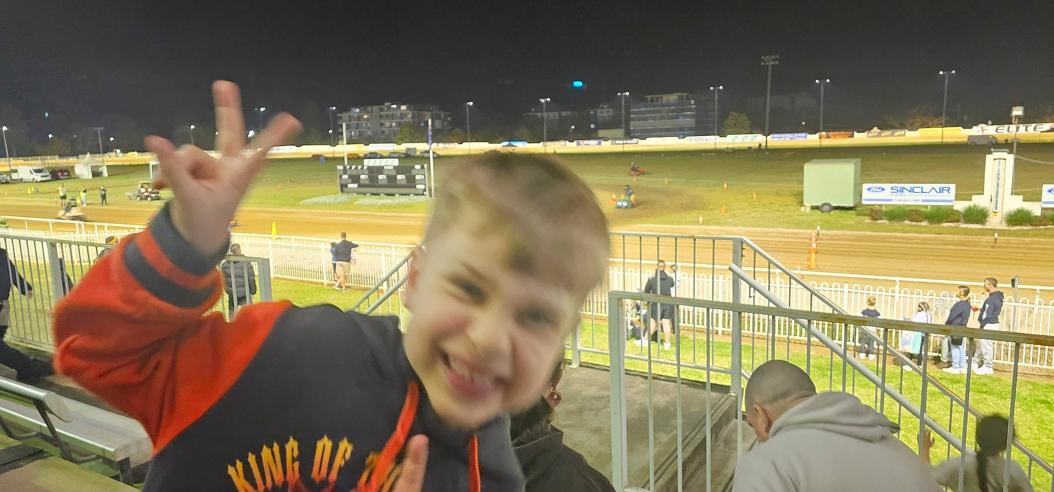 Archer is registered to the contest to win money with this photo: arena, ball_game, championship, clothing, competition_event, crowd, event, fan, fence, fun, gesture, grass, joy, leisure, person, player, smile, sport_venue, sports, stadium