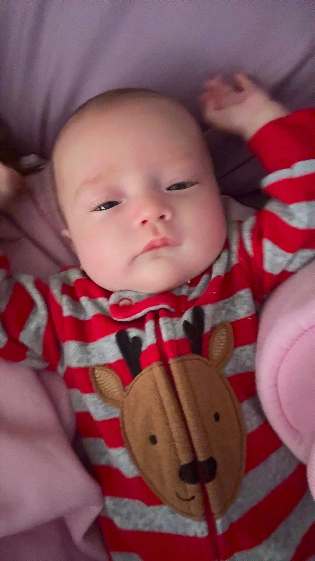 Sky is registered to the contest to win money with this photo: baby, infant, sleepy, onesie, red_stripes, gray_stripes, reindeer, plush, blanket, bed, cute, child, portrait, indoors, soft_texture, clothing, face, head, resting, young