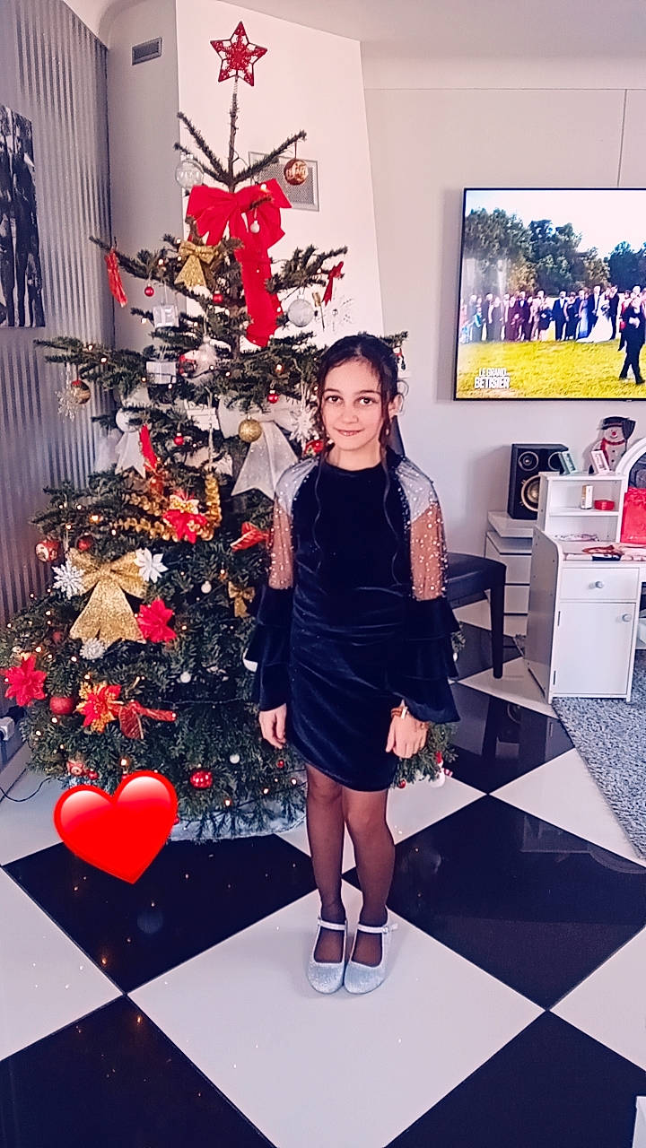 Hilary participe au concours pour gagner de l'argent avec cette photo : christmas, christmas_decoration, christmas_ornament, christmas_tree, conifer, event, fashion_design, flooring, fun, hairstyle, holiday, holiday_ornament, human_leg, joy, ornament, pattern, person, room, shoe, standing