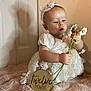 Aaliyah Rosalina is registered to the contest to win money with this photo: baby, child, twelve_months, flower, daisy, dress, headband, bow, blanket, indoor, portrait, cute, milestone, infant, soft_texture, wooden_sign, curious, sitting, person, celebration