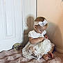 Aaliyah Rosalina joined the competition — help win amazing prizes! baby, child, girl, white_dress, headband, lace, sitting, blanket, door, shadow, floor, indoor, milestone, sign, feet, cute, portrait, infant, soft_texture, curious