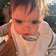 Nolan participe au concours pour gagner de l'argent avec cette photo : baby, bib, big_eyes, candid, cheeks, close_up, cute, drool, expression, eyelashes, hair, hand_holding, infant, outdoor, person, portrait, skin, striped_clothing, sunlight, tattoo_on_hand