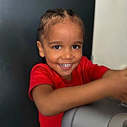 Kalys participe au concours pour gagner de l'argent avec cette photo : background, braided_hair, casual, child, cute, expression, eyes, face, happy, indoor, leaning, lighting, mouth, person, portrait, red_shirt, skin, smiling, teeth, young