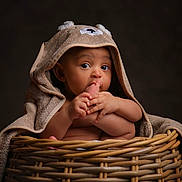 Ezra is registered to the contest to win money with this photo: baby, infant, towel, basket, foot, cute, child, portrait, skin, hand, face, eyes, naked, cozy, soft, brown, animal_hood, curious, indoor, cute_expression