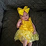 Giavanna is registered to the contest to win money with this photo: baby, infant, yellow_bow, yellow_dress, flower_pattern, quilted_couch, indoor, cute, portrait, child, small_hands, small_feet, headband, seated, looking_at_camera, fabric_texture, soft_lighting, adorable, clothing, newborn