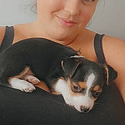 Stormi is registered to the contest to win money with this photo: woman, puppy, dog, pet, smile, face, black_clothing, indoor, portrait, cute, animal, resting, young_woman, black_and_white, fur, head, eyes, skin, happy, closeup