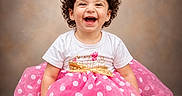 Victoria Grace joined the competition — help win amazing prizes! toddler, child, smiling, happy, curly_hair, hair_clip, white_tshirt, pink_tutu, polka_dots, golden_bow, sitting, barefoot, portrait, studio, background, cute, joyful, fashion, celebration, baby