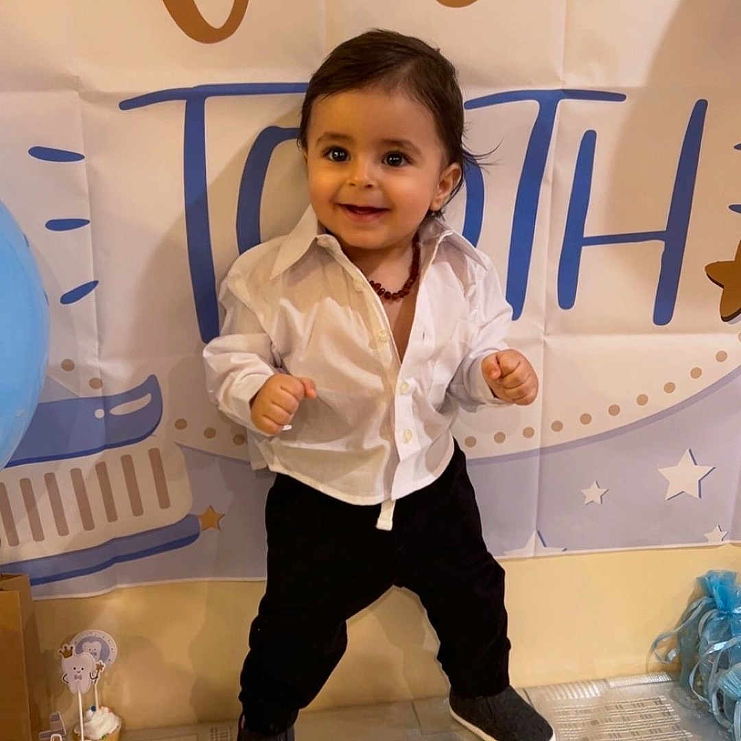 Ezel joined the competition — help win amazing prizes! background, black_pants, celebration, child, cupcakes, decorations, event, face, first_tooth, hair, happy, indoors, party, person, shoes, smiling, standing, table, toddler, white_shirt