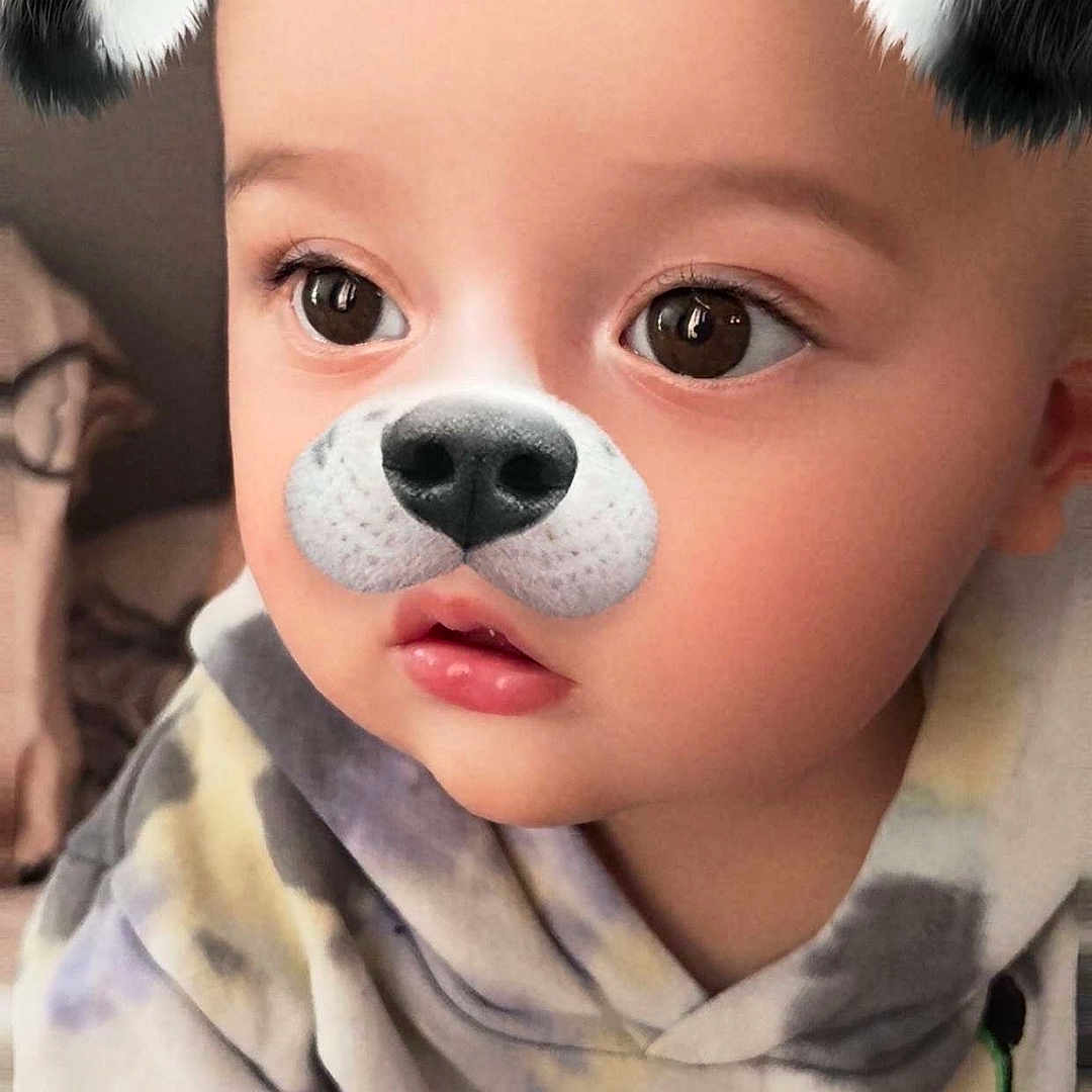 Harvey is registered to the contest to win money with this photo: baby, child, closeup, clothing, cute, digital_filter, dog_filter, ears, expression, eyes, face, hoodie, indoor, nose, playful, portrait, skin, tie_dye, toddler, young_child