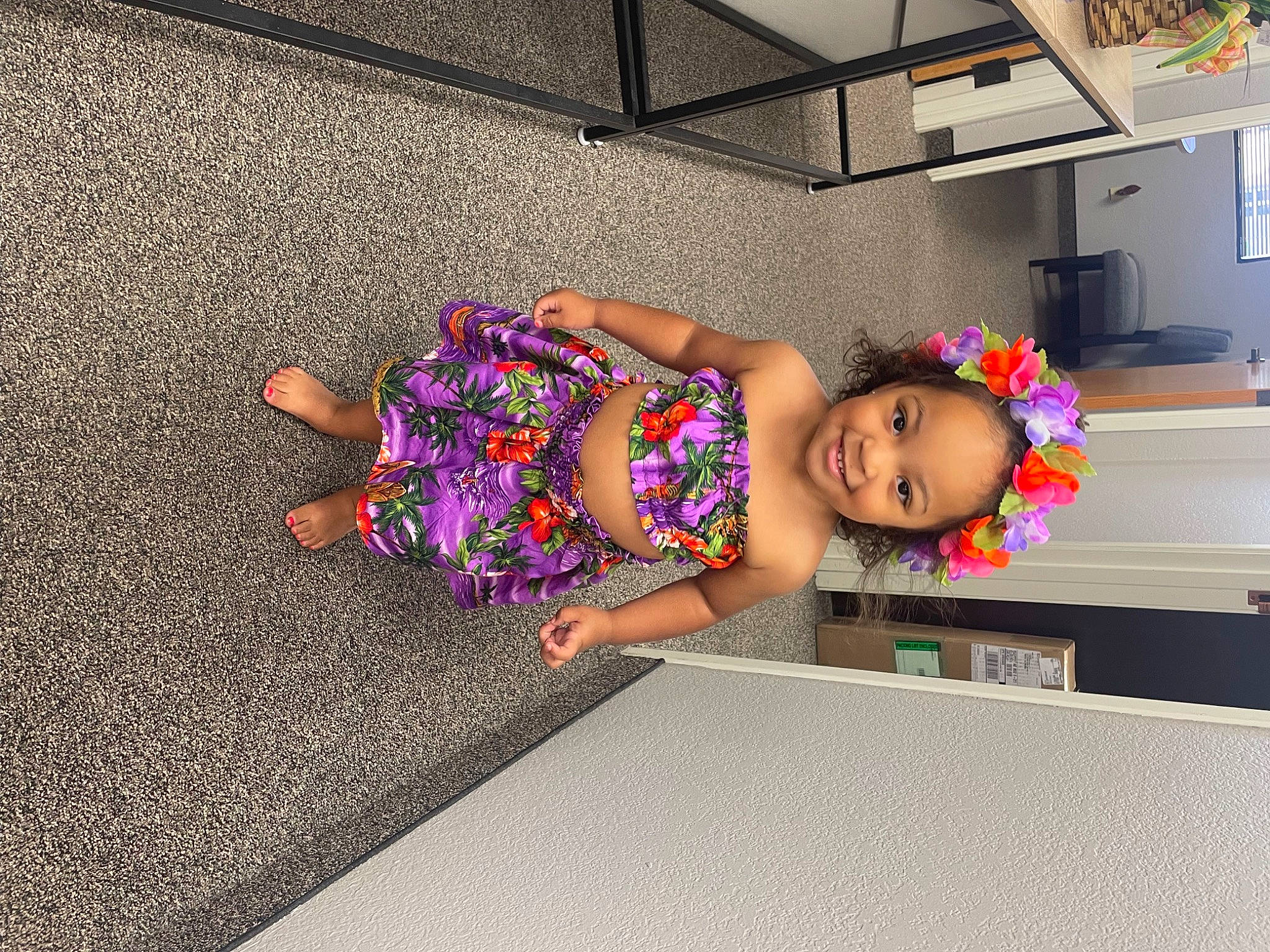 Aleia is registered to the contest to win money with this photo: baby_toddler_clothing, child, dress, floor, flooring, flower, fun, happy, house, human_leg, joy, leisure, magenta, pattern, person, plant, play, purple, sandal, smile