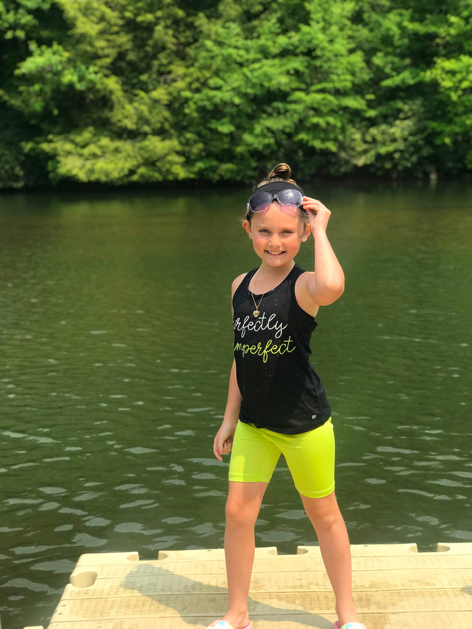 Kynleigh is registered to the contest to win money with this photo: eyewear, flash_photography, fun, grass, happy, headwear, human_leg, joy, knee, lake, leisure, person, personal_protective_equipment, recreation, reservoir, shorts, smile, sportswear, sunglasses, thigh