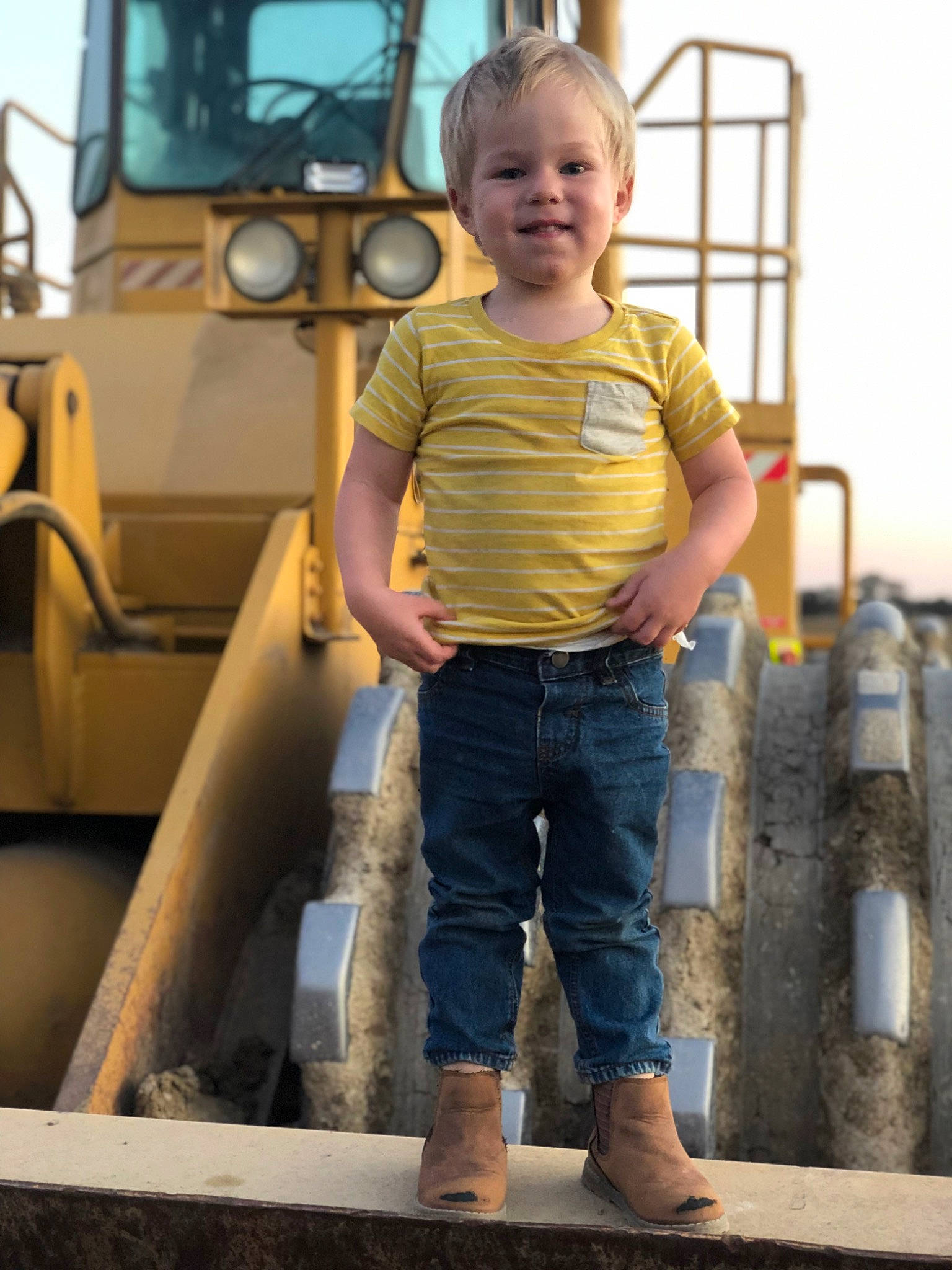 Kobi is registered to the contest to win money with this photo: child, city, clothing, denim, face, fun, gas, joy, leisure, outdoor_play_equipment, person, playground, recreation, shorts, sky, sleeve, smile, soil, t_shirt, toddler