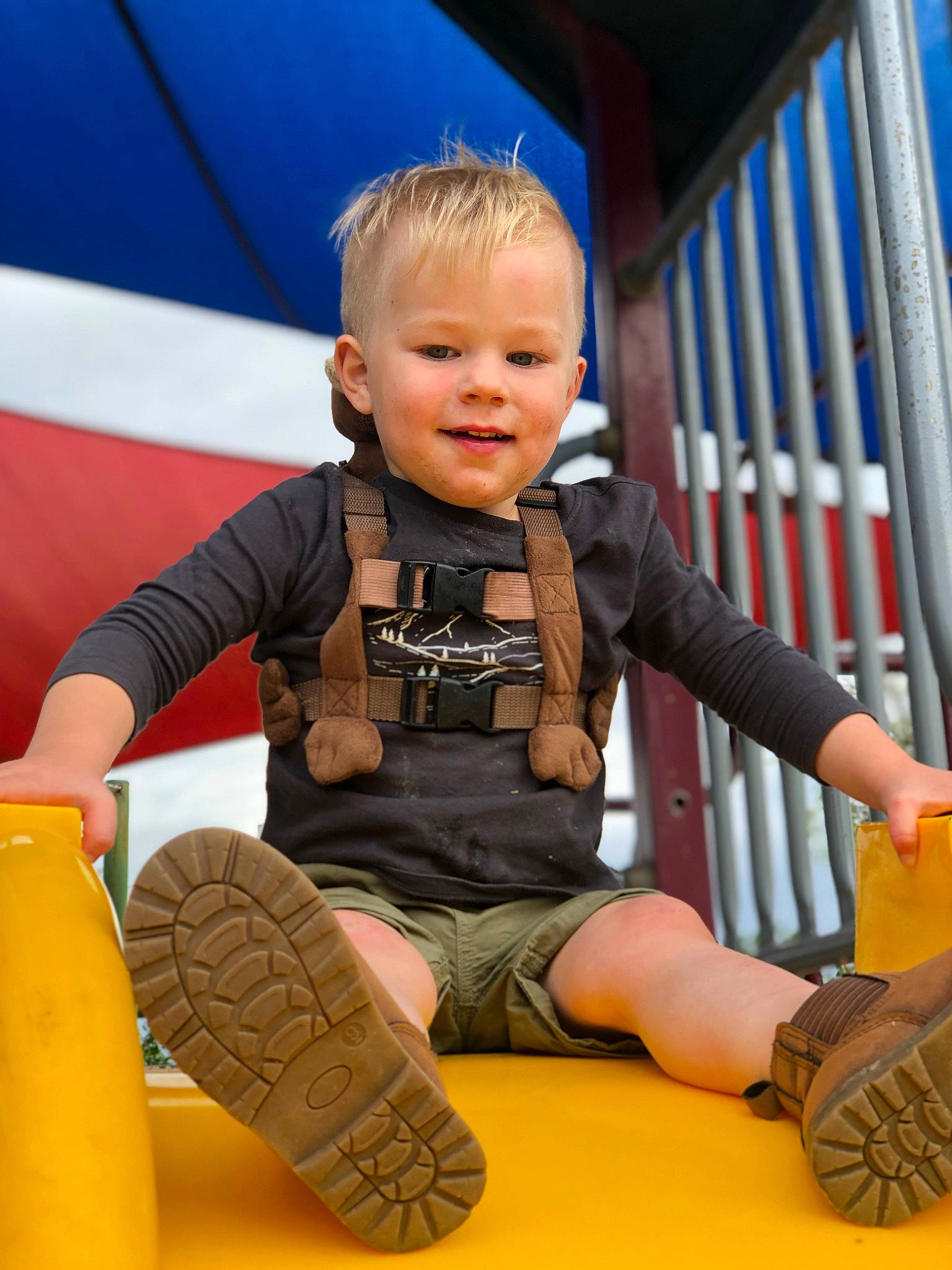 Kobi joined the competition — help win amazing prizes! baby, blue, child, city, fun, happy, joy, leisure, orange, outdoor_play_equipment, people, person, play, playground, recreation, shorts, sitting, smile, sneakers, summer