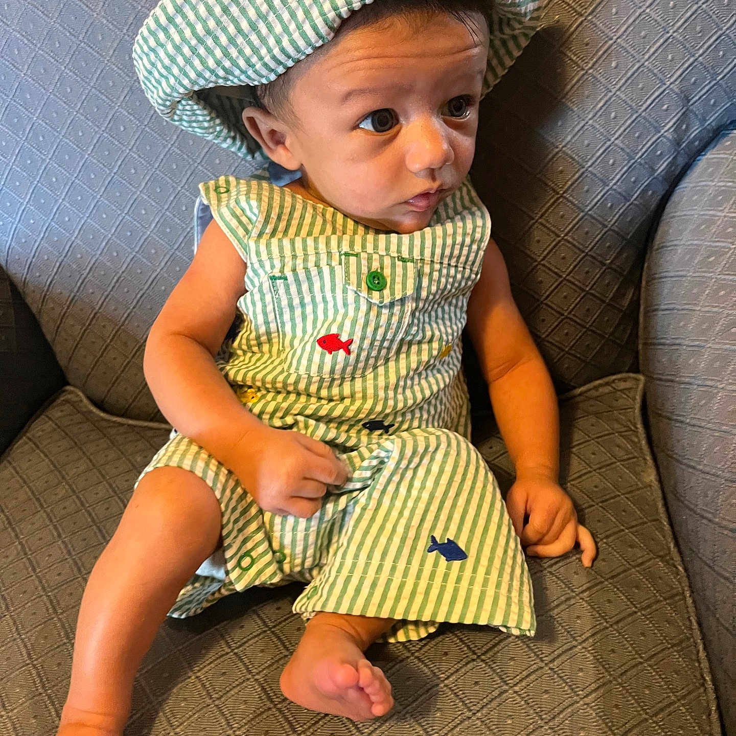 Amoni is registered to the contest to win money with this photo: baby, bonnet, cap, chair, clothing, couch, cushion, dress, face, furniture, hat, head, homedecor, person, photography, portrait, shorts, sitting, sleeve, sunhat