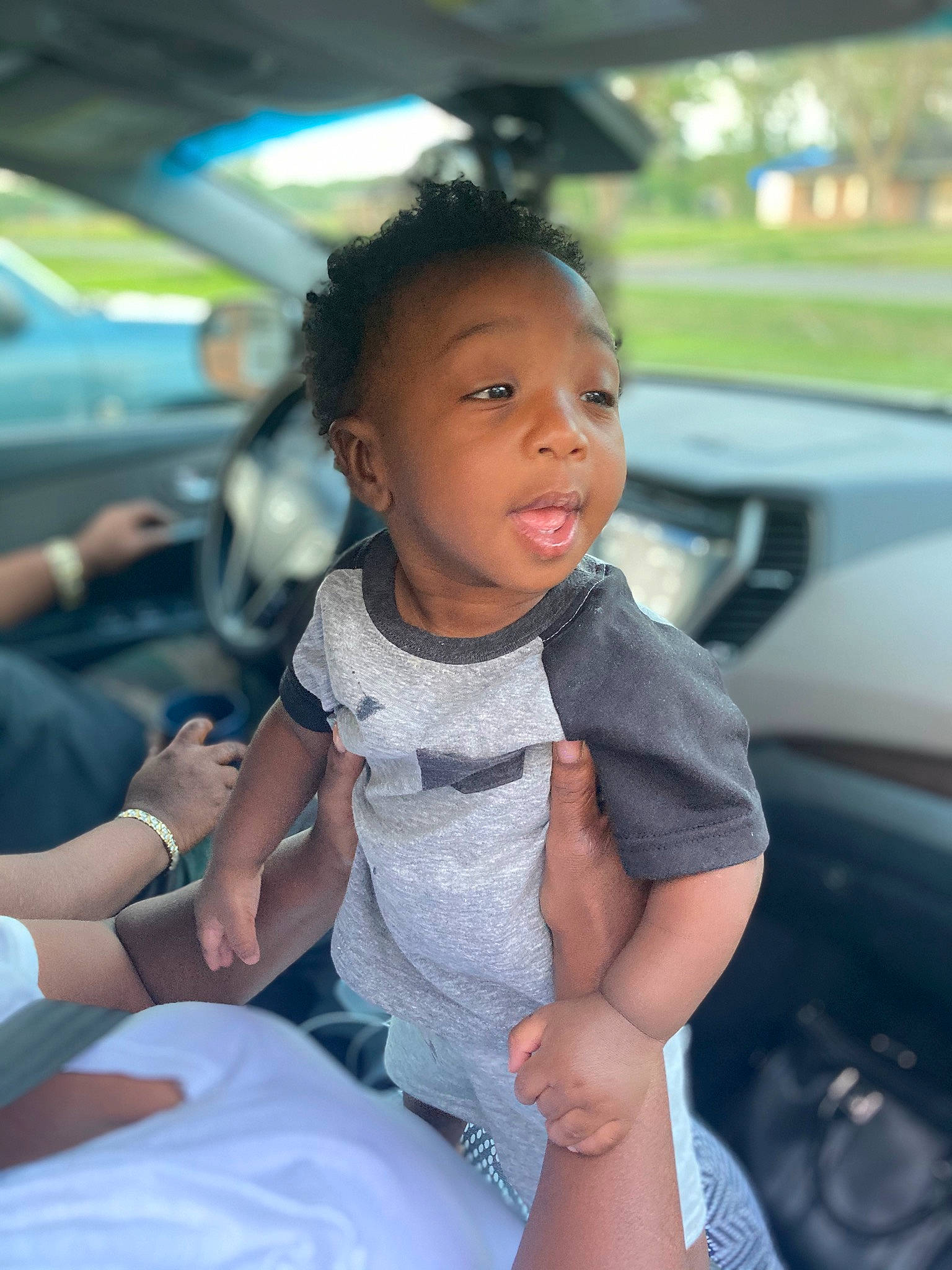 Izayn is registered to the contest to win money with this photo: auto_part, automotive_design, baby_toddler_clothing, black_hair, car_seat, fun, gesture, happy, leisure, mode_of_transport, motor_vehicle, passenger, people, person, skin, smile, steering_wheel, thumb, toddler, travel