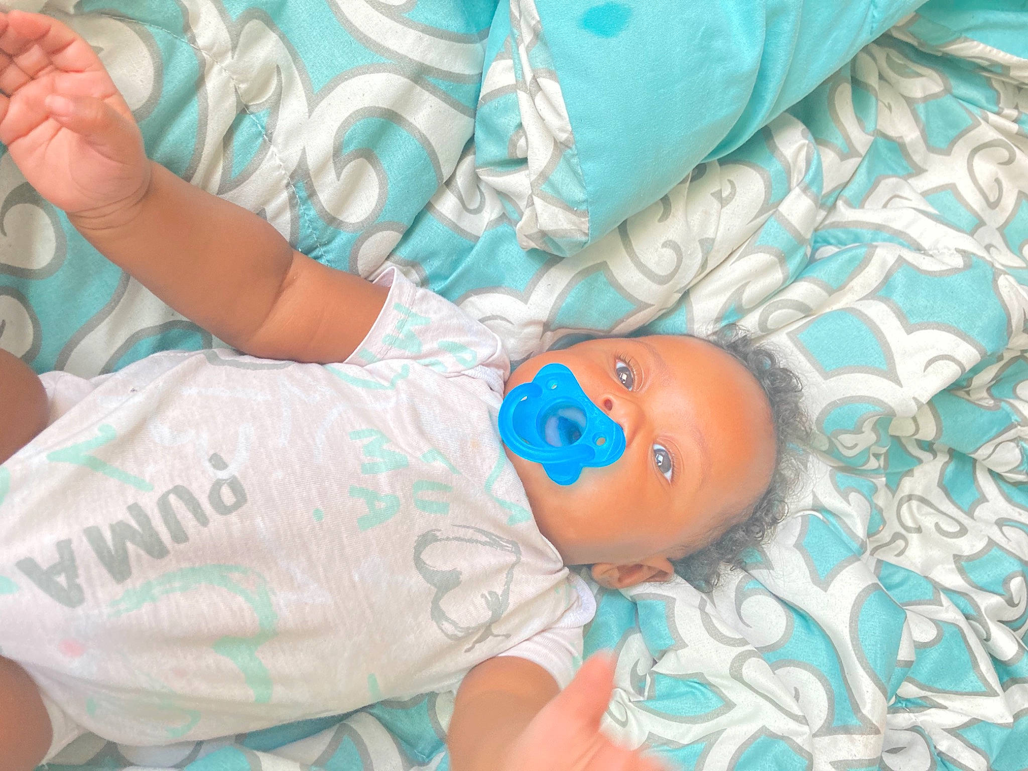 Journie is registered to the contest to win money with this photo: aqua, azure, baby, baby_products, baby_toddler_clothing, child, comfort, elbow, electric_blue, gesture, human_body, joint, linens, mouth, pattern, person, room, skin, textile, thigh