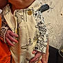 newborn, baby, infant, onesie, animal_print, hand, legs, face, person, indoor, blanket, remote_control, fabric, holding, cute, clothing, pattern, skin, sitting, cozy