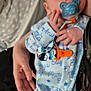 baby, pacifier, hand, onesie, blue_clothing, infant, sleepwear, person, sparkles, soft_focus, cute, newborn, child, sleepsuit, bed, blanket, holding, comfort, indoor, portrait