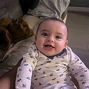 Sasha a rejoint le concours — aidez-le/la à gagner de superbes lots ! baby, smile, onesie, infant, cute, happy, indoor, blanket, couch, person, child, patterned_clothing, face, human, holding, cozy, animal_print, living_room, portrait, young_child