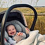 baby, car_seat, blanket, smiling, outdoor, wildflowers, fence, grass, happy, infant, nature, child, seatbelt, cozy, cute, portrait, sunlight, peaceful, field, young