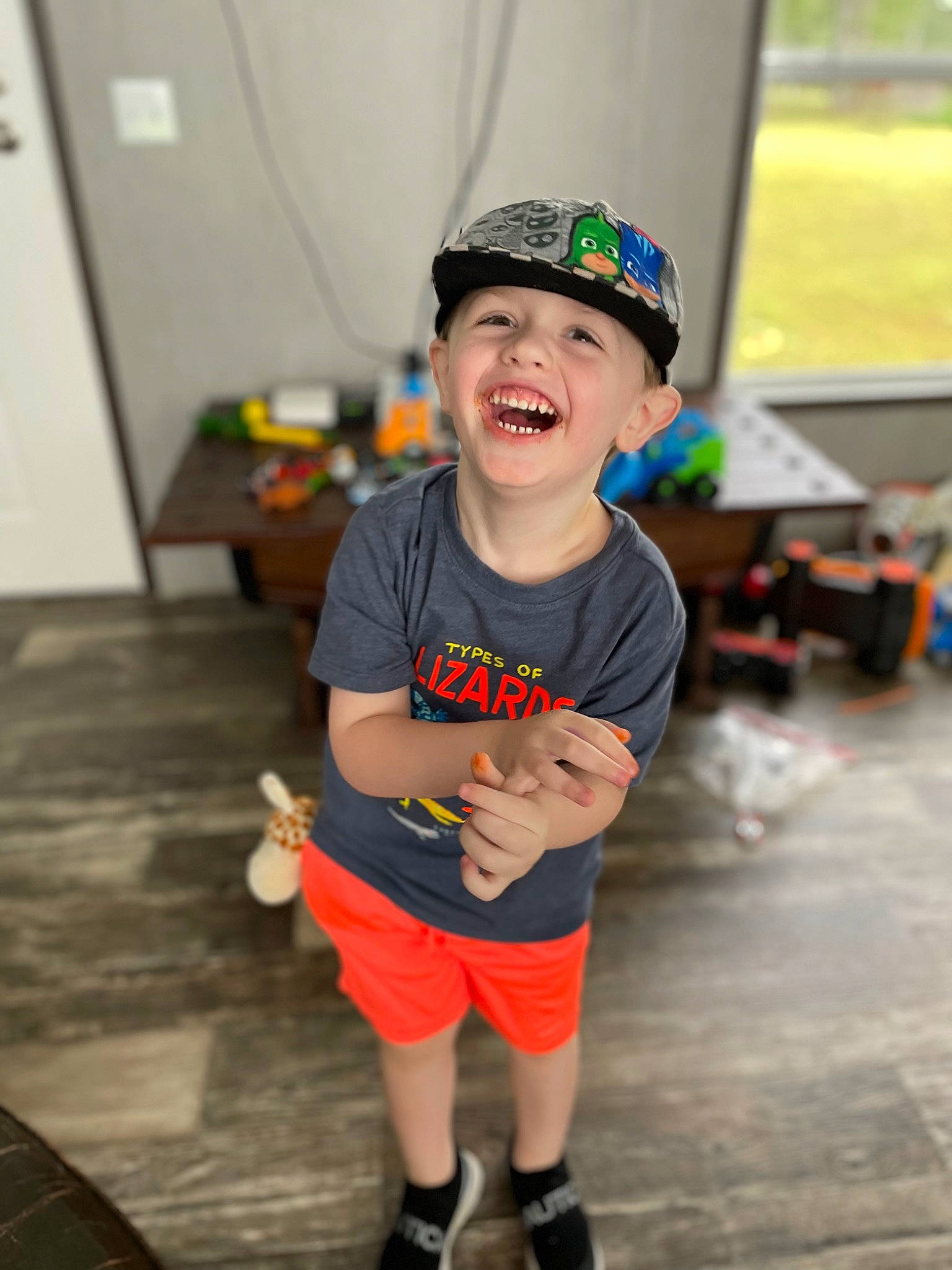 Lawson is registered to the contest to win money with this photo: baseball_cap, cap, child, event, flooring, fun, happy, hat, headwear, human_leg, knee, leisure, person, recreation, sandal, shoe, shorts, smile, standing, t_shirt