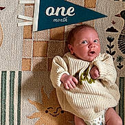 Camden joined the competition — help win amazing prizes! baby, blue_pennant, child, cozy, cute, diaper, expression, indoor, infant, knit_sweater, laying_down, newborn, one_month, patterned_rug, portrait, small_feet, small_hands, smiling_sun, soft_lighting, text