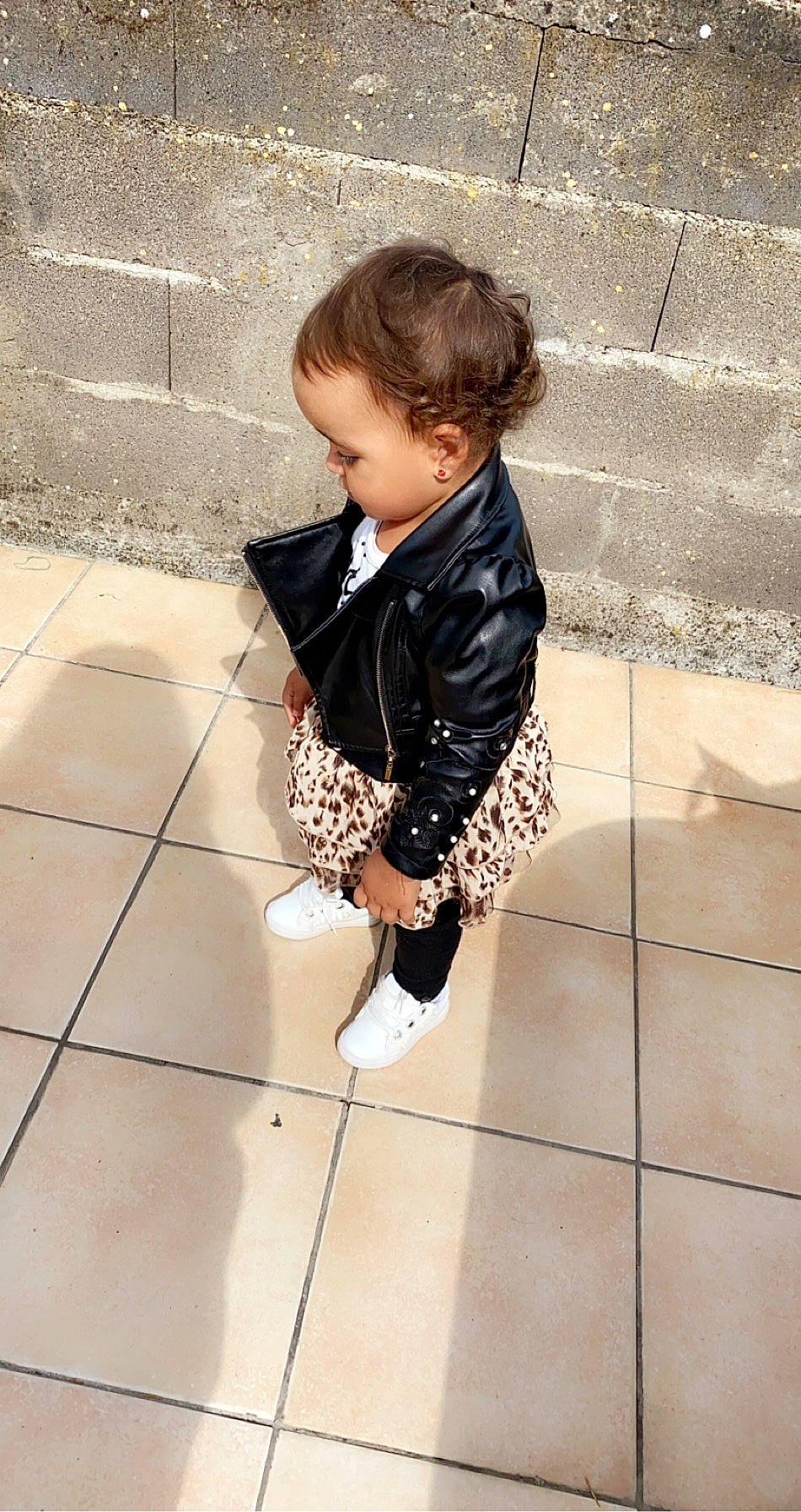 Tracy participe au concours pour gagner de l'argent avec cette photo : baby, child, cobblestone, floor, flooring, human_body, human_leg, leg, outerwear, pattern, person, road_surface, sidewalk, sitting, sleeve, street_fashion, suit, thigh, toddler, waist