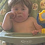 Karter is registered to the contest to win money with this photo: toddler, child, high_chair, bored, indoor, toy, green, patterned, furniture, seat, baby, expression, hand, face, hair, skin, sitting, grip, tray, clothing