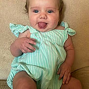 Kacelynn is registered to the contest to win money with this photo: baby, blue_eyes, child, clothing, couch, cute, green_dress, hair_bow, hand, happy, head, indoor, infant, legs, person, portrait, sitting, skin, smiling, tongue_out