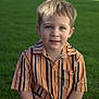 child, boy, grass, outdoor, portrait, smile, shirt, striped_shirt, casual, sitting, face, young, cute, daylight, nature, happy, person, kid, summer, park