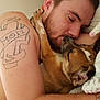 Hunter is registered to the contest to win money with this photo: man, dog, sleeping, cuddling, tattoo, paw, beard, bed, blanket, pillow, face, arm, close_up, intimate, cozy, pet, resting, snuggle, nose, ears