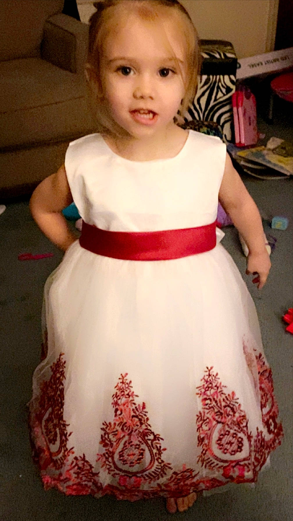 Amelia is registered to the contest to win money with this photo: baby_toddler_clothing, cheek, child, clothing, day_dress, dress, embellishment, flooring, formal_wear, happy, neck, one_piece_garment, pattern, person, shoulder, sleeve, t_shirt, toddler, trunk, waist