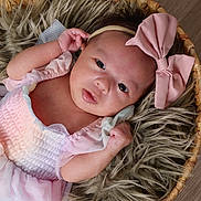 Cataleyah is registered to the contest to win money with this photo: baby, infant, newborn, basket, headband, bow, dress, pink, fur_rug, blanket, eyes, hands, face, portrait, closeup, cute, skin, wooden_floor, props, photography