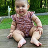 baby, casual_clothing, child, cute, grass, greenery, happy, infant, nature, outdoor, pigtails, playful, portrait, sitting, skin, smiling, summer, sunlight, trees, wooden_surface