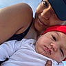 Zamir is registered to the contest to win money with this photo: baby, adult, cap, hat, white_clothing, red_hat, sky, outdoor, selfie, smile, portrait, person, headwear, face, skin, arm, hand, close_up, expression, casual