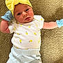 baby, infant, yellow_bow, mittens, lemon_pattern, white_shirt, blue_pants, carpet, lying_down, cute, portrait, face, headband, clothing, child, soft_texture, indoor, young, person, newborn