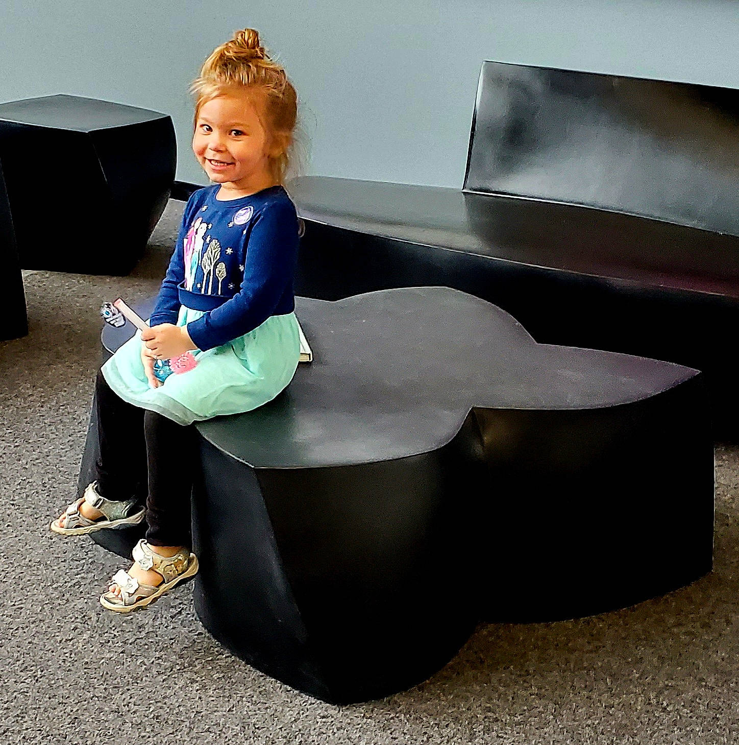 Cheyanne is registered to the contest to win money with this photo: automotive_design, comfort, couch, dress, electric_blue, flooring, formal_wear, happy, human_leg, joy, knee, person, sandal, shoe, sitting, sleeve, smile, sportswear, t_shirt, table