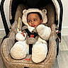 Kayden a rejoint le concours — aidez-le/la à gagner de superbes lots ! baby, car_seat, infant, onesie, plush_clothing, indoor, flooring, curious_expression, pouty_face, child, seatbelt, brown, white, fur_texture, headgear, cushioned_seat, person, childcare, cute, warm_clothing