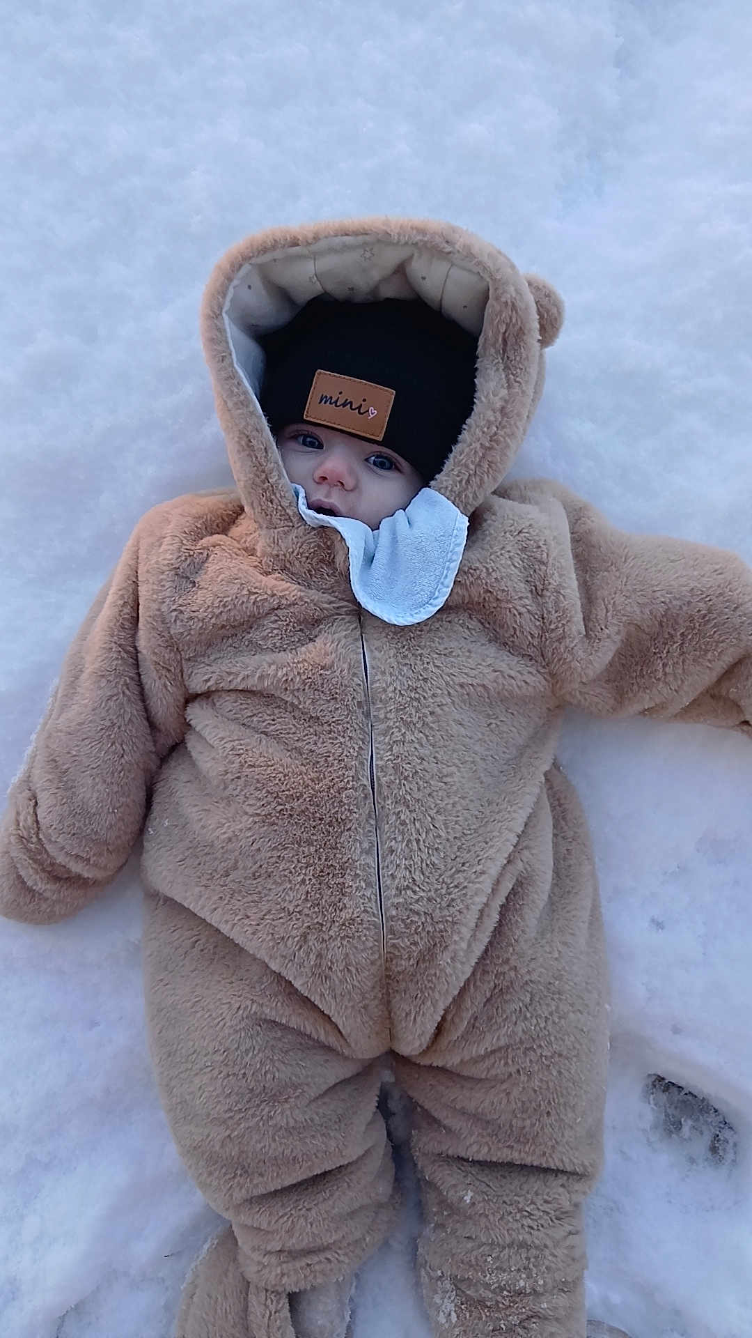 Eliott participe au concours pour gagner de l'argent avec cette photo : baby, snow, winter_clothing, hat, face, child, outdoor, cold_weather, cute, infant, one_person, fur_suit, lying_down, frozen, winter, portrait, warm_clothing, baby_suit, cold, adorable