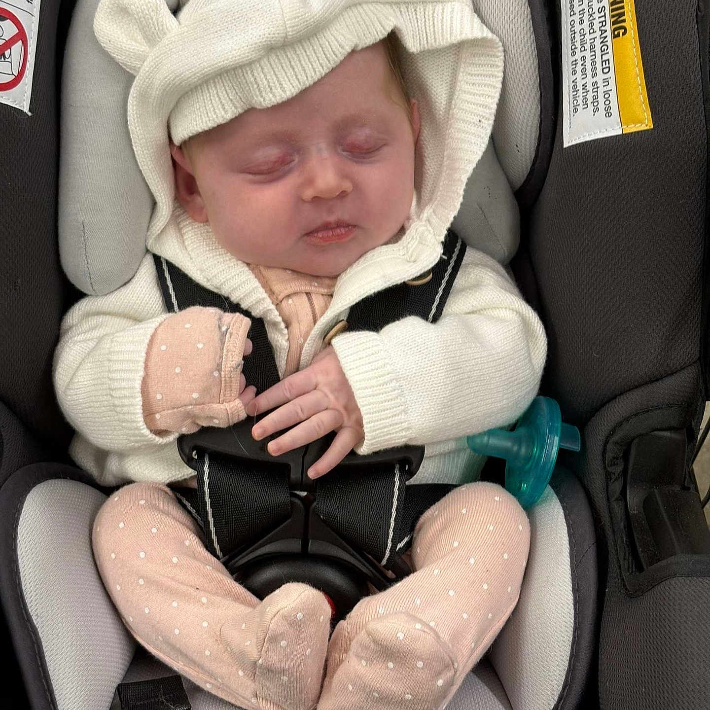 Sara is registered to the contest to win money with this photo: baby, bonnet, car, car_interior, carseat, clothing, coat, face, hat, head, jacket, newborn, person, photography, portrait, sad, sitting, sleeping, transportation, vehicle