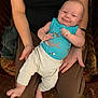 Dominic joined the competition — help win amazing prizes! baby, infant, smiling, tank_top, shark_pattern, pants, barefoot, adult, lap, hands, chair, blanket, carpet, indoor, person, relaxing, comfort, cute, portrait, home
