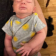 Dominic joined the competition — help win amazing prizes! baby, sleeping, onesie, yellow_sun, arm, person, wooden_floor, dog, black_dog, hand, infant, cute, cozy, indoor, peaceful, child, human, portrait, relaxing, toddler