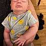 baby, sleeping, onesie, yellow_sun, arm, person, wooden_floor, dog, black_dog, hand, infant, cute, cozy, indoor, peaceful, child, human, portrait, relaxing, toddler